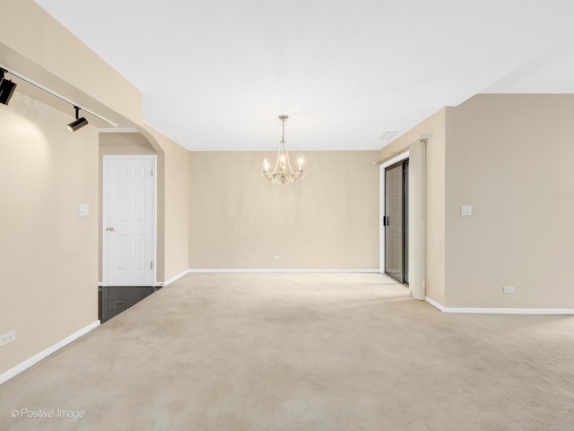 1409 Burr Oak Rd Unit 109A, Hinsdale, IL 60521 - empty room featuring a chandelier, arched walkways, baseboards, and carpet flooring