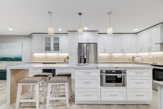 1409 Burr Oak Rd Unit 109A, Hinsdale, IL 60521 - kitchen featuring stainless steel appliances, white cabinets, backsplash, recessed lighting, and light stone countertops