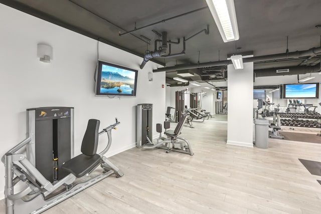 workout area featuring wood finished floors and baseboards