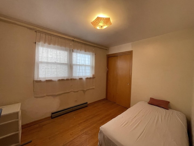 733 E 90th St, Chicago, IL 60619 - bedroom with a baseboard radiator, wood finished floors, a closet, and baseboards