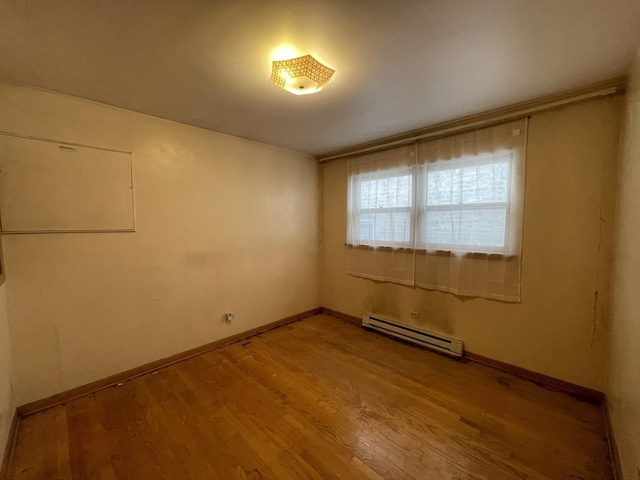 733 E 90th St, Chicago, IL 60619 - spare room with baseboard heating, wood finished floors, and baseboards