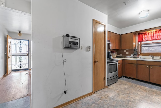 733 E 90th St, Chicago, IL 60619 - kitchen featuring electric stove, a sink, brown cabinetry, and light countertops