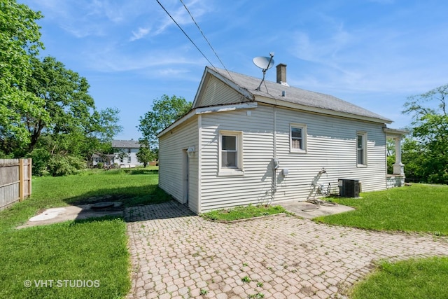 rear view of house featuring a patio, central AC, and a chimney