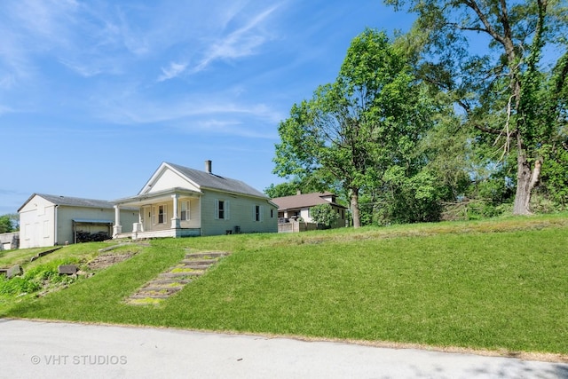 view of front of home featuring an attached garage, a front lawn, and a porch