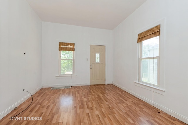 foyer entrance with light wood-style flooring and baseboards