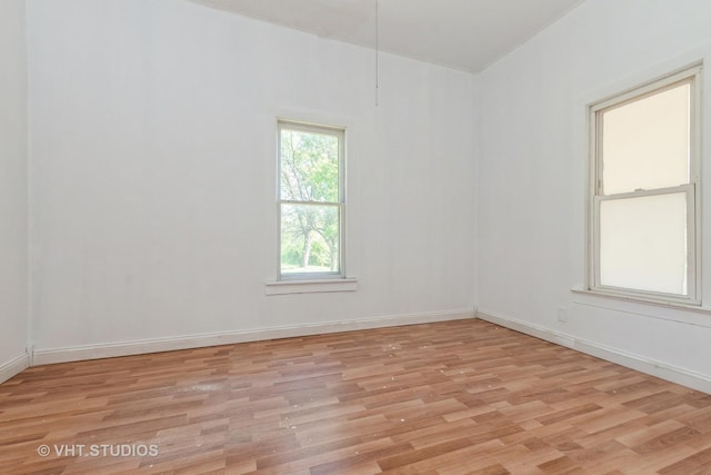 spare room with light wood-type flooring and baseboards