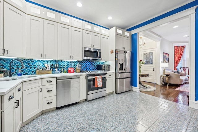 4914 S Washington Park Ct, Chicago, IL 60615 - kitchen with stainless steel appliances, light countertops, a sink, tasteful backsplash, and a chandelier