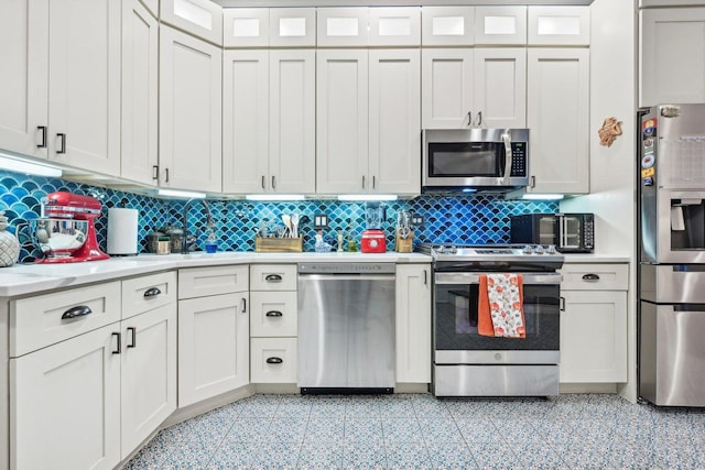 4914 S Washington Park Ct, Chicago, IL 60615 - kitchen featuring stainless steel appliances, light countertops, backsplash, and white cabinets