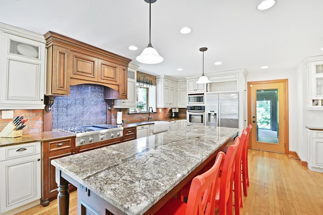 24 Robin Crest Rd, Hawthorn Woods, IL 60047 - kitchen with appliances with stainless steel finishes, a breakfast bar area, decorative backsplash, recessed lighting, and a sink