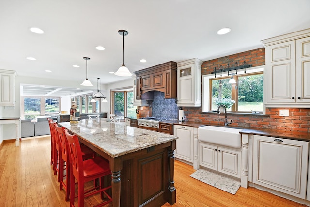 24 Robin Crest Rd, Hawthorn Woods, IL 60047 - kitchen with a sink, dark stone countertops, light wood-style floors, a center island, and tasteful backsplash