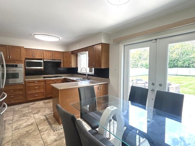 1402 Berry Ln, Flossmoor, IL 60422 - kitchen with stainless steel appliances, a sink, brown cabinets, french doors, and under cabinet range hood