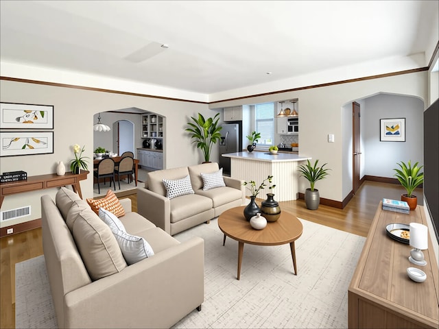 living area featuring arched walkways, light wood-style floors, and baseboards