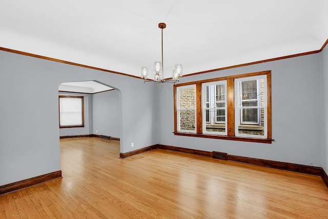 unfurnished room with arched walkways, baseboards, light wood-style flooring, a chandelier, and ornamental molding