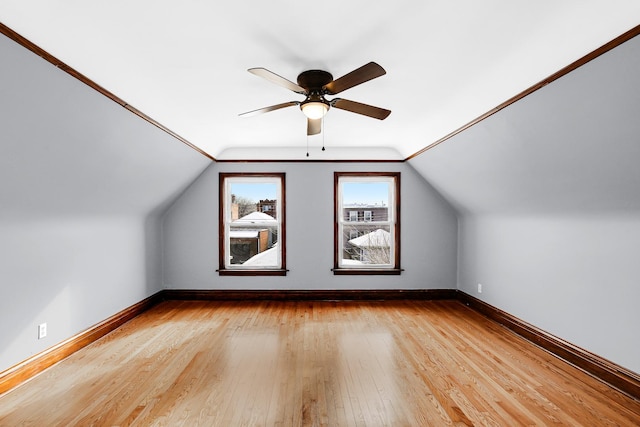 bonus room featuring baseboards, light wood-style floors, a ceiling fan, and vaulted ceiling