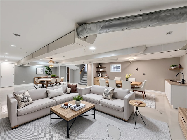 living room featuring stairs, baseboards, recessed lighting, and concrete flooring