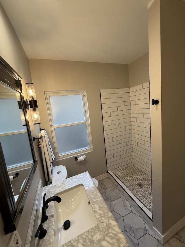 full bathroom with a tile shower, marble look tiles, baseboards, and vanity