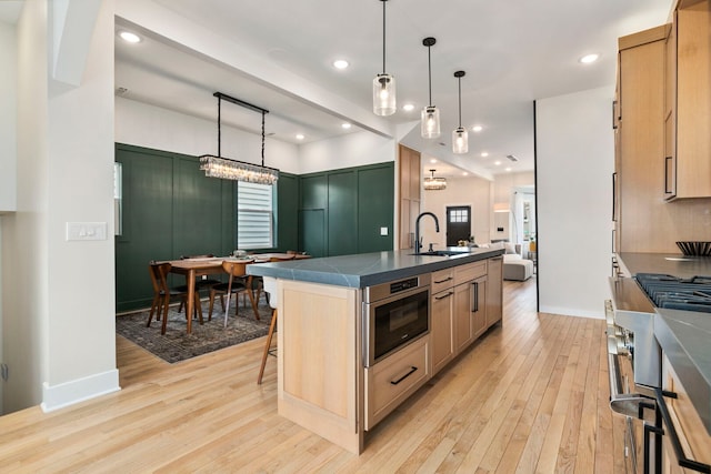3104 N Sacramento Ave, Chicago, IL 60618 - kitchen featuring a sink, dark countertops, light wood finished floors, and recessed lighting