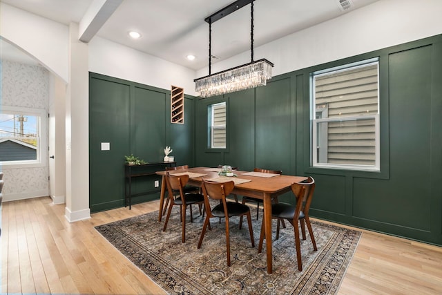 3104 N Sacramento Ave, Chicago, IL 60618 - dining room featuring a chandelier, light wood-style flooring, arched walkways, recessed lighting, and a decorative wall