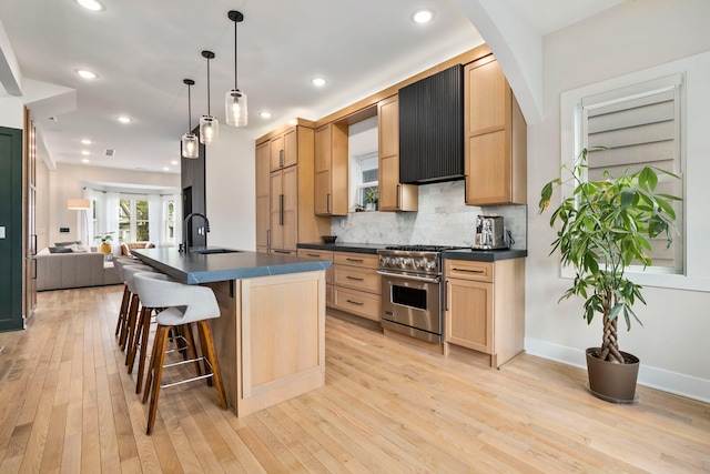 3104 N Sacramento Ave, Chicago, IL 60618 - kitchen featuring stainless steel range, dark countertops, a sink, open floor plan, and light wood-style flooring