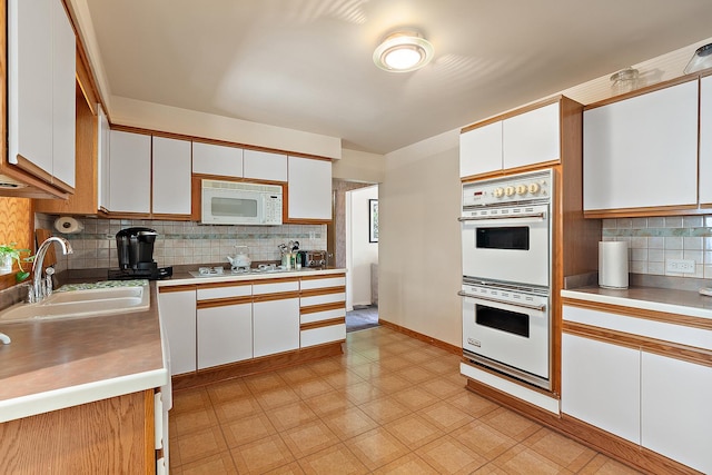 7009 W 115th Pl, Worth, IL 60482 - kitchen with a sink, white appliances, white cabinetry, decorative backsplash, and light countertops