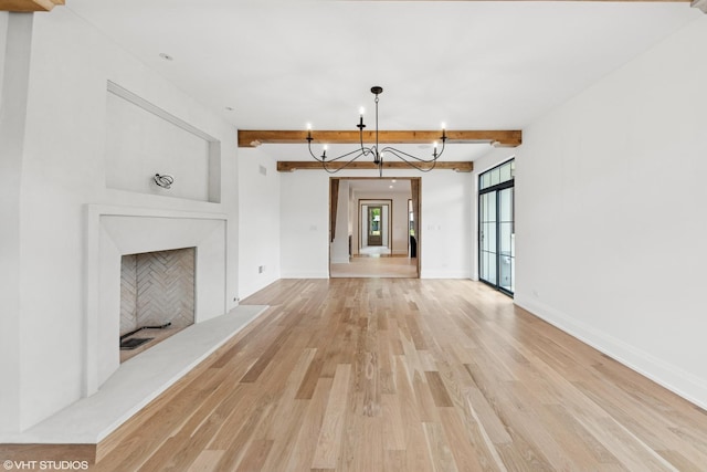 1107 Quassey Ave, Lake Bluff, IL 60044 - unfurnished living room featuring light wood-type flooring, beamed ceiling, a chandelier, and a fireplace with raised hearth