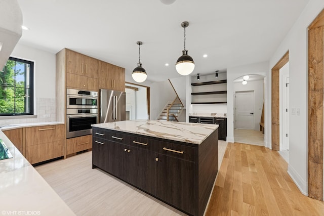 1107 Quassey Ave, Lake Bluff, IL 60044 - kitchen featuring stainless steel appliances, open shelves, a center island, light wood finished floors, and backsplash