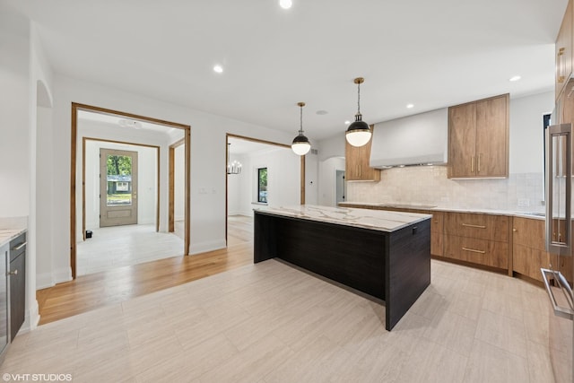 1107 Quassey Ave, Lake Bluff, IL 60044 - kitchen featuring wall chimney exhaust hood, brown cabinets, a kitchen island, backsplash, and modern cabinets