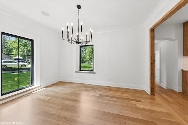 1107 Quassey Ave, Lake Bluff, IL 60044 - unfurnished room with a chandelier, light wood-style floors, ornamental molding, and arched walkways
