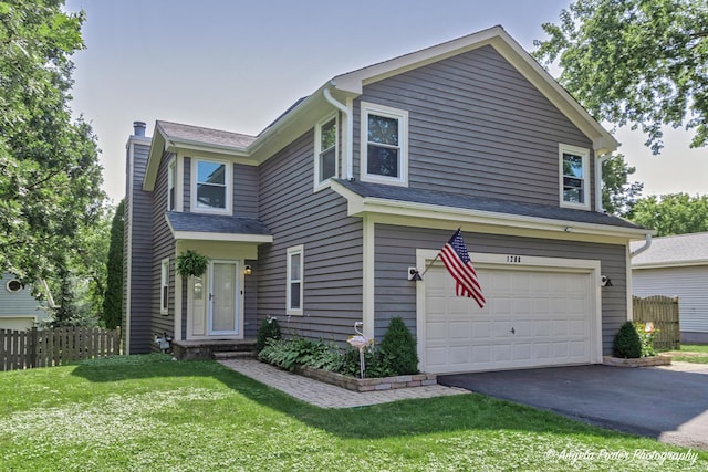 traditional-style house with a chimney, a garage, driveway, and a shingled roof