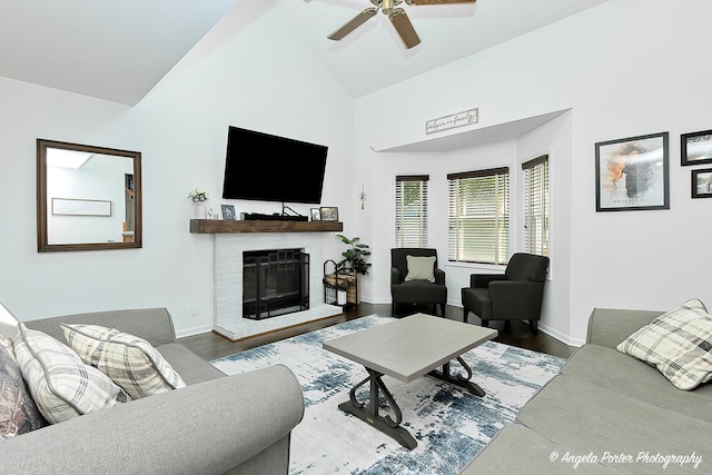 living room with high vaulted ceiling, ceiling fan, wood finished floors, a fireplace, and baseboards