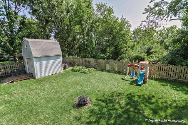 view of yard featuring a storage shed, an outbuilding, and a fire pit