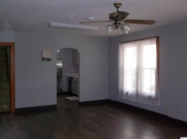 1619 Locust, Quincy, IL 62301 - unfurnished room featuring arched walkways, ceiling fan, dark wood-style floors, and baseboards