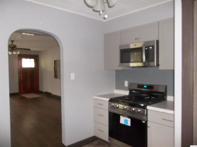 1619 Locust, Quincy, IL 62301 - kitchen featuring appliances with stainless steel finishes, arched walkways, a ceiling fan, light countertops, and dark wood finished floors