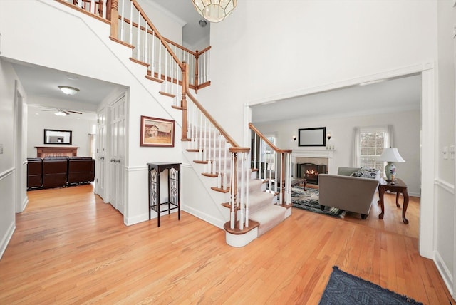 625 Fielding Place Ct, Barrington, IL 60010 - foyer featuring a warm lit fireplace, hardwood / wood-style flooring, stairway, a towering ceiling, and a ceiling fan