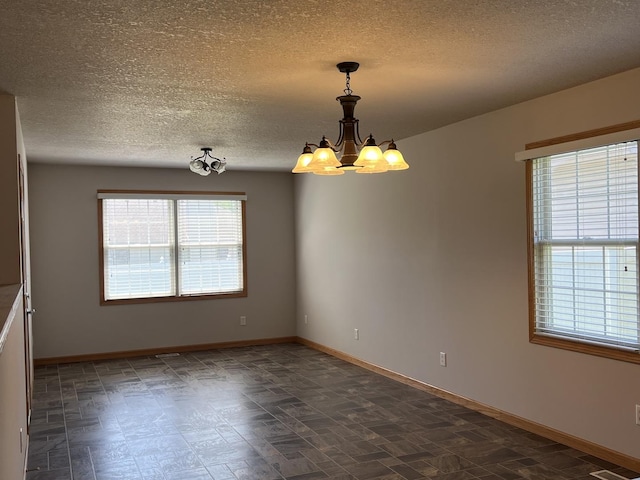 330 Centerpoint Dr, Bourbonnais, IL 60914 - empty room featuring a chandelier, a textured ceiling, and baseboards