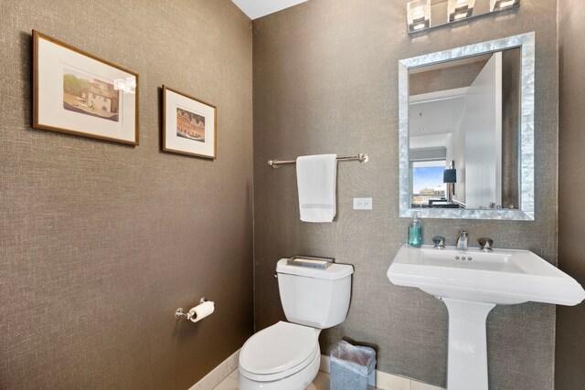 half bathroom featuring toilet and a sink
