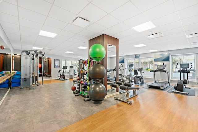 workout area featuring a paneled ceiling and wood finished floors