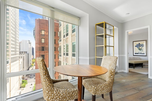 dining space featuring wood finished floors, ornamental molding, baseboards, and a view of city