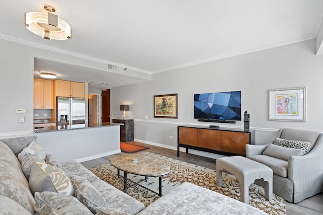 living room with crown molding, light wood-style flooring, and baseboards