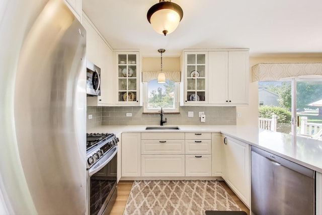 5506 Hickory Grove Ct, Plainfield, IL 60586 - kitchen with stainless steel appliances, a sink, decorative backsplash, decorative light fixtures, and light countertops