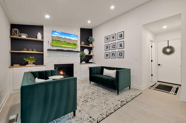 living room with a large fireplace, recessed lighting, light wood-style flooring, and baseboards