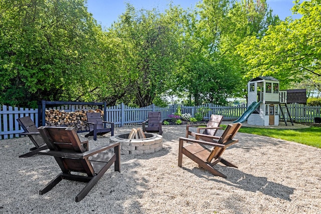 view of patio featuring an outdoor fire pit, fence, and a playground