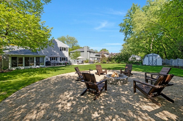 view of patio with a fire pit, a storage shed, a sunroom, and an outdoor structure