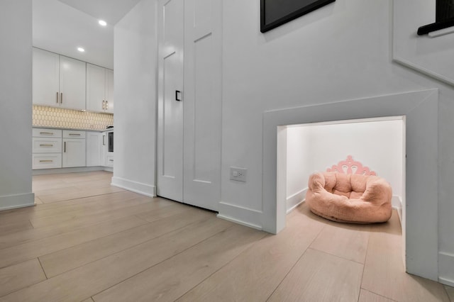 corridor featuring light wood finished floors and recessed lighting