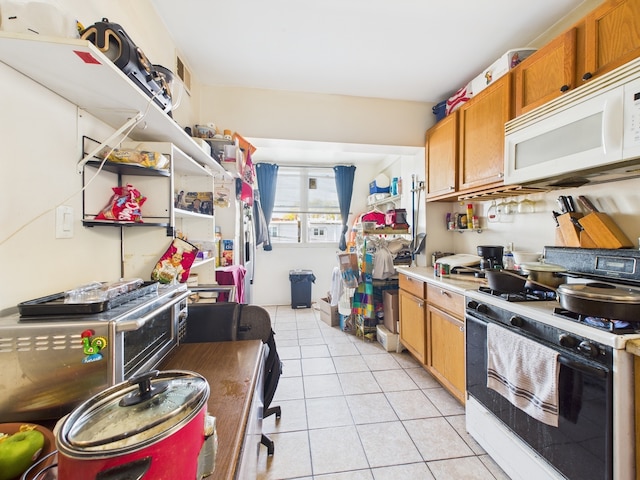4810 W Strong St, Chicago, IL 60630 - kitchen with white appliances, light tile patterned flooring, brown cabinets, and light countertops