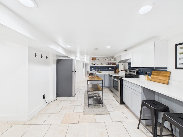 4810 W Strong St, Chicago, IL 60630 - kitchen featuring stainless steel appliances, backsplash, light countertops, under cabinet range hood, and open shelves