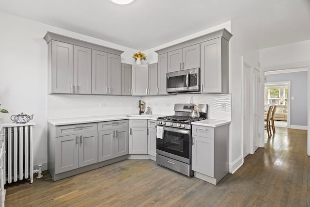 2018 N Laporte Ave, Chicago, IL 60639 - kitchen with appliances with stainless steel finishes, gray cabinetry, radiator heating unit, and backsplash