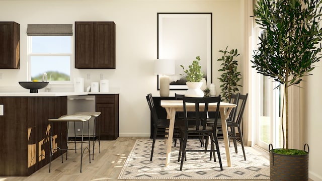 dining area featuring light wood-style flooring and baseboards
