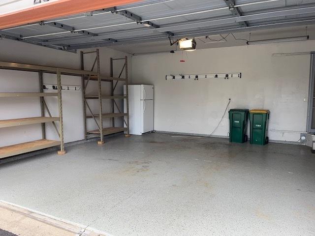 20827 W Torrey Pines Ln, Plainfield, IL 60544 - garage with freestanding refrigerator and a garage door opener
