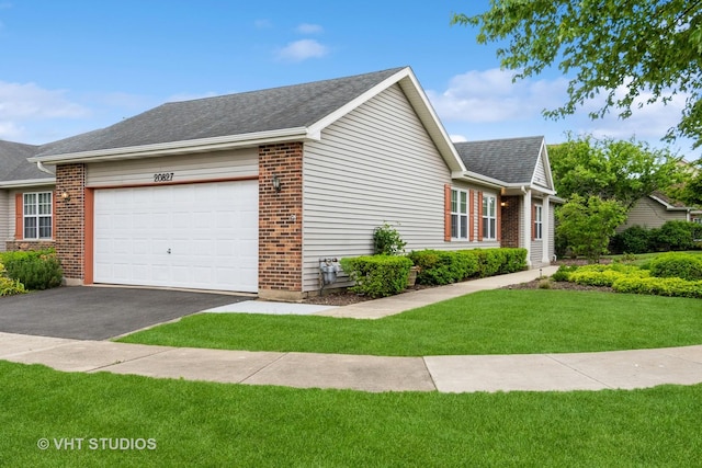 20827 W Torrey Pines Ln, Plainfield, IL 60544 - view of home's exterior featuring an attached garage, driveway, a lawn, brick siding, and a shingled roof